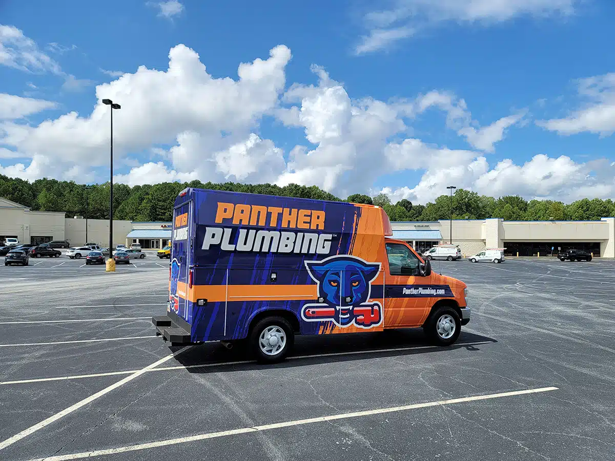 The Panther Plumbing truck parked in a commercial parking lot.