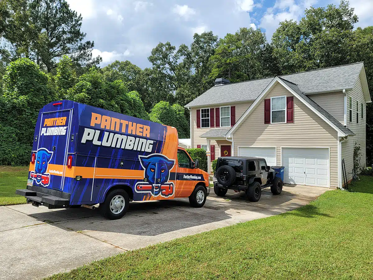 The Panther Plumbing truck parked in the driveway of a residential home in Austell, GA.