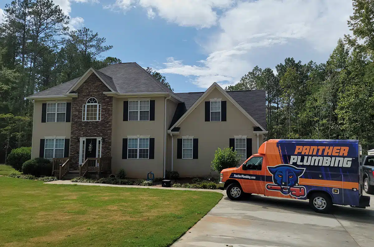 The Panther Plumbing truck parked in the driveway of a residential home in Austell, GA.